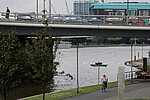 VGF-Bahn beim grauen Wetter am Main in Frankfurt, die über eine Brücke fährt