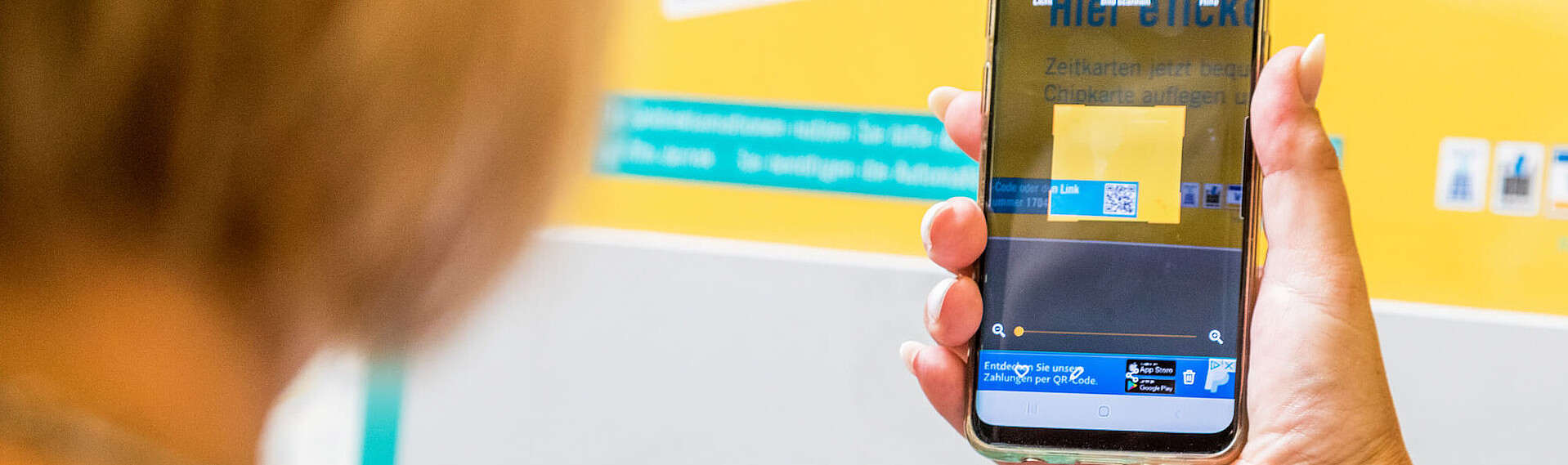 Kundin öffnet mit dem QR-Code das Kontaktformular zur Automaten-Geldreklamation.