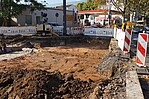 Baustelle Straßenaufbruche mit Absperrpfosten und Tankstelle im Hintergrund