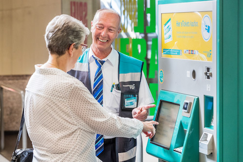 [Translate to English:] Verkaufsstellen -  VGF-Mitarbeiterin erklärt einer Kundin den Kauf einer Fahrkarte am Automaten