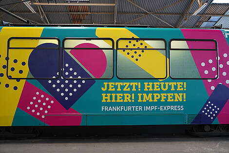 Impfexpress der VGF von der Seite mit bunten Pflastern auf dem Wagen