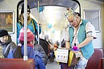 Clown mit VGF-Weste im VGF-Wagon mit Fahrgästen