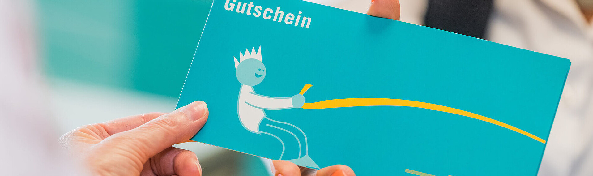 Mitarbeiterin überreicht einer Kundin einen Gutschein der VGF.
