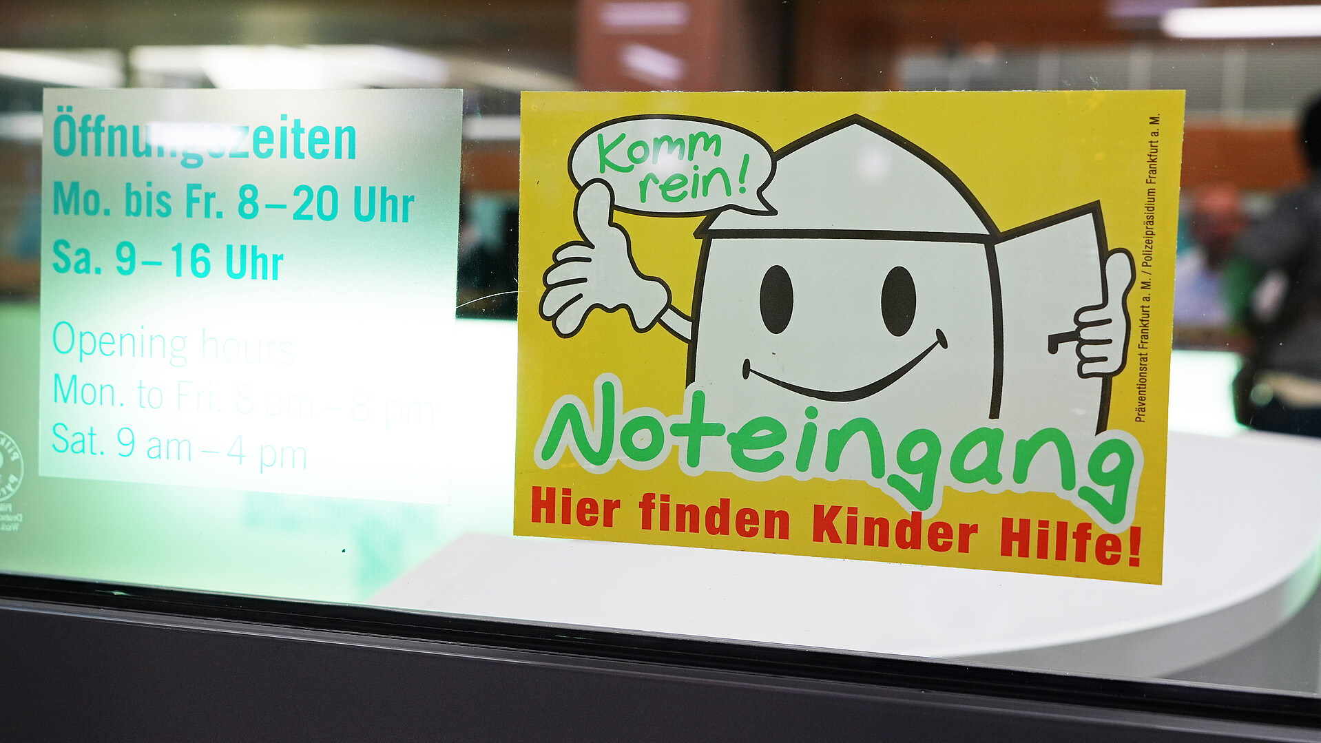Das Bild zeigt den Aufkleber für den Kindernoteingang, der an einem Fenster angebracht ist.