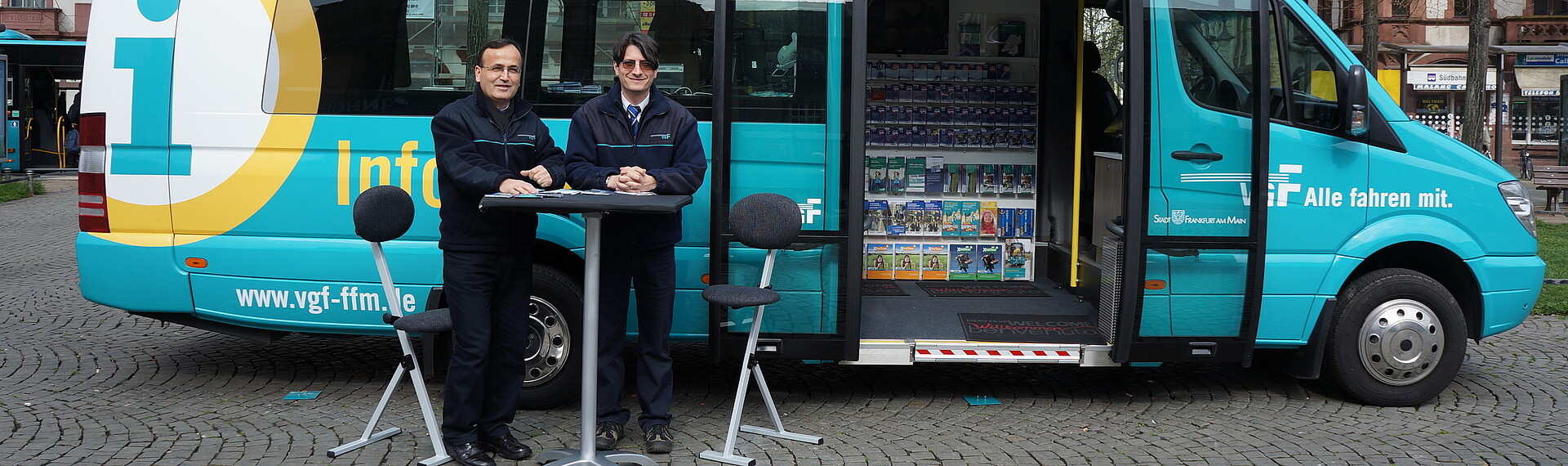 Zwei VGF-Mitarbeiter am Stehtisch vor einem Infobus der VGF