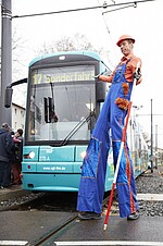 Bauarbeiter auf Stelzen vor einer VGF-U-Bahn