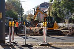 Straßenbaustelle mit Bagger und Absperrpfosten