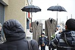 Zwei Regenmäntel mit Regenschirmen ohne Kopf als Photobooth