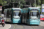 Zwei VGF-Bahnen auf Schienen bei schönem Wetter bei der Fahrt im Straßenverkehr