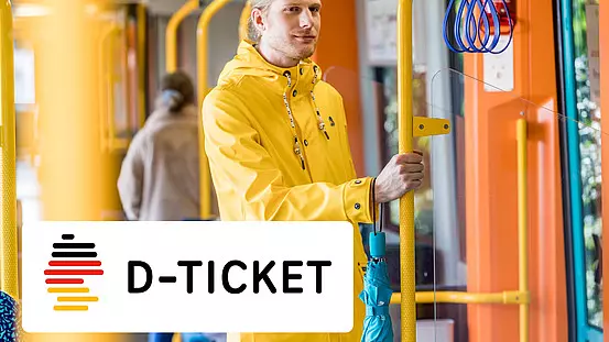 Mann mit gelber Regenjacke in der U-Bahn stehend.