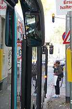 Ausschnit eines Rückspiegels der VGF-BAhn an einer Haltestelle