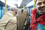 Fahrgäste im VGF-Wagen mit Shootingmöglichkeit neben grauen Mantel