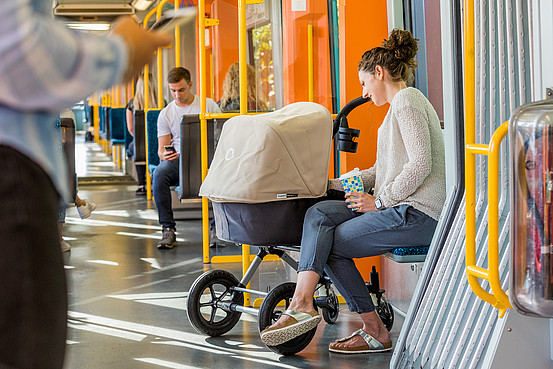 Frau mit Kinderwagen in der VGF-U-Bahn, die eine RMV-Fahrkarte ab 9:00 Uhr nutzt zum Fahren.