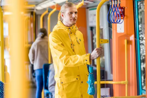 [Translate to English:] Wochenkartenkäufer mit Regenjacke in der Bahn