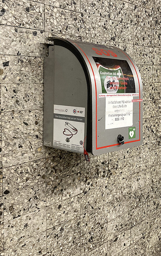 Das Bild zeigt einen Defibrillator an der Wand einer U-Bahnstation