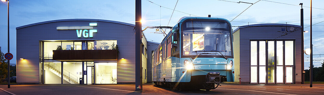 VGF-Gebäude mit einer VGF-Bahn bei Abenddämmerung